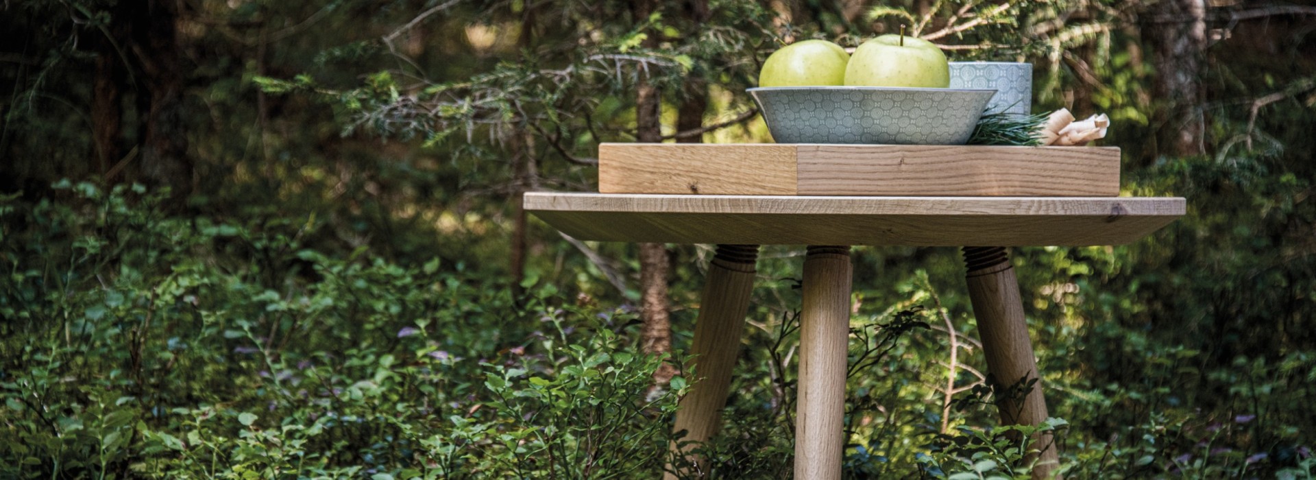 Runder Holztisch aus robustem Massivholz inmitten der Natur.