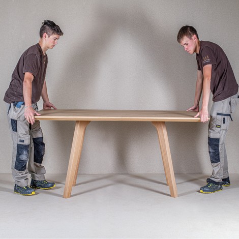 Mitarbeiter der Tischlerei Weissteiner beim Aufbau der Tischplatte auf die Stützen aus Massivholz