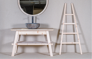 Ein Waschtisch mit steinernem Waschbecken mit Spiegel und eine Holzleiter mit vier Sprossen fürs Badezimmer.