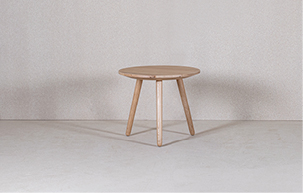 Ein kleiner, runder Holztisch mit drei Beinen und einer stabilen Platte aus heimischem Holz.