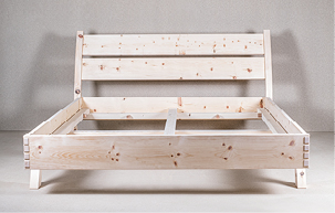 Ein Holzbett aus heimischem Massivholz mit schrägem Rücken