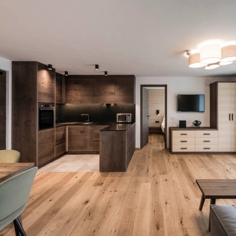 Kitchen-living room with wooden floor, wooden cupboard, wooden tables and wooden furnishing of the kitchenette