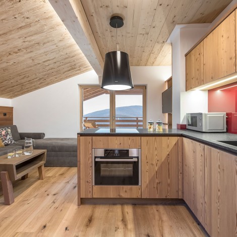 Kitchenette made of local wood and small wooden table in front of the sofa