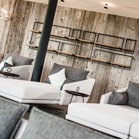 Wellness area with relaxation loungers and wooden wall with wooden shelves in the background